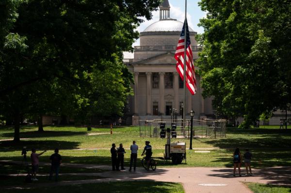 The American flag was returned to its place and is now guarded by a barricade. 