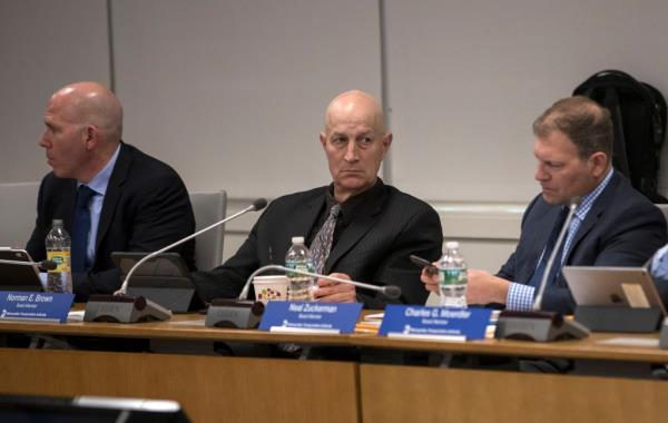 MTA Board Member Norman Brown sitting at a meeting regarding the new L train plan in New York City